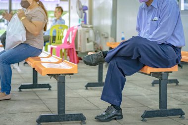 Yaşlı erkek gezgin, Corona Virüsü 'nü (COVID-19) önlemek için koruyucu yüz maskesi takıyor. Nakliye istasyonunda minibüsü beklerken not alın. Yeni normal yaşam tarzı, salgın durumu, seçici odaklanma