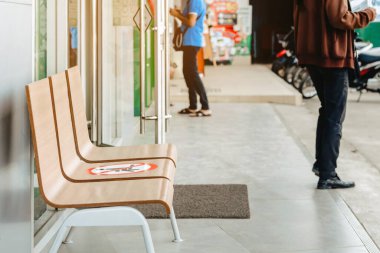 Corona Virüsü 'nden (COVID-19) korunmak için diğer insanlardan bir koltuk için banka mesafesinin önündeki sosyal mesafe kuralları için alternatif oturma noktası, enfeksiyon riski için sosyal mesafe.