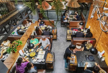 KANCHANABURI, THAILAND-HAZİRAN 26 Haziran 2020: Kimliği belirsiz Asyalı aile Vietnam yemekleriyle güzel yemek ve içecekler yiyor, eğleniyor ve PHO Dayı HO restoranında iletişim kuruyor.
