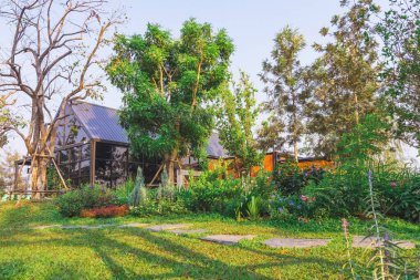 KANCHANABURI, THAILAND - 19 Şubat 2021: PTT benzin istasyonundaki Kafe Amazon kahve dükkanının güzel bahçe dekorasyonu. Cafe Amazon, PTT Kamu Şirketi Limited 'in sahibi olduğu Tayland kahveleri zinciri..