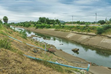 Beton duvardaki sulama kanalı ya da sulama kanalı çiftçinin tarımsal alanına su gönderin.