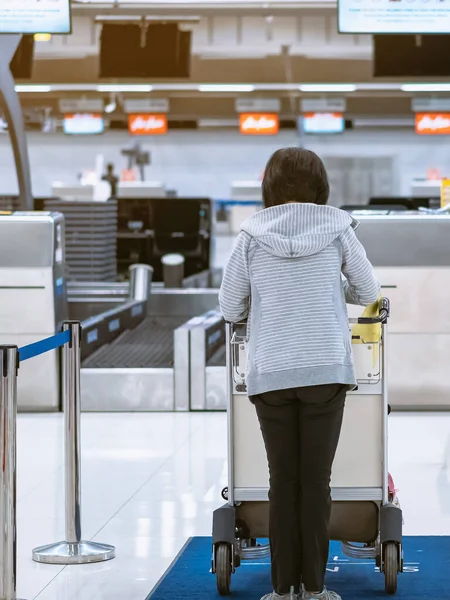 Corona virüsünü (Covid-19) önlemek için havaalanında personel maskesi takan yolcuların arka görüntüsü yüz maskesi takılır. Covid-19 salgınından sonra yeni normal seyahat kavramı.