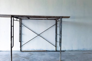 İç yapı inşaatı ve beton duvarların boyanması için yapı iskelesi sağlayın. İskeleli boş beyaz oda. Tadilat sırasında eski bir ev. İnşaat alanının içindeki eski yapı iskelesi..