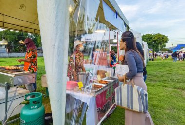 KANCHANABURI, THAILAND - 12 Eylül 2020: Kimliği belirsiz insanlar eski kağıt fabrikasında Covid 19 salgını sırasında yerel marketlerde alışveriş yapmak için yüz maskesi takarak mikroplardan korunuyor.