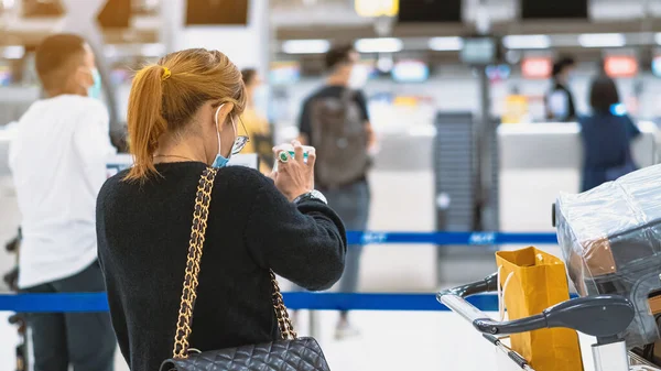 Corona virüsünü (Covid-19) önlemek için havaalanında personel maskesi takan yolcuların arka görüntüsü yüz maskesi takılır. Covid-19 salgınından sonra yeni normal seyahat kavramı.