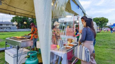 KANCHANABURI, THAILAND - 12 Eylül 2020: Kimliği belirsiz insanlar eski kağıt fabrikasında Covid 19 salgını sırasında yerel marketlerde alışveriş yapmak için yüz maskesi takarak mikroplardan korunuyor.