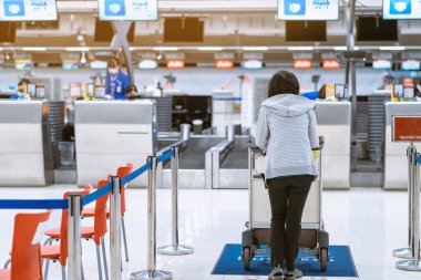 Corona virüsünü (Covid-19) önlemek için havaalanında personel maskesi takan yolcuların arka görüntüsü yüz maskesi takılır. Covid-19 salgınından sonra yeni normal seyahat kavramı.