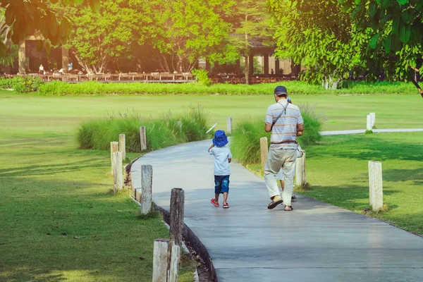 Baksidan Asiatiska Far Och Son Promenader Väg Genom Grön Trädgård — Stockfoto