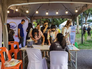 KANCHANABURI, THAILAND-SEPTEMBER 12, 2020: Coronavirus (Covid-19) salgınını önlemek için giriş öncesi QR kod veya kayıt defteri kullanılarak vücut ısısının incelenmesi ve kayıt defteri
