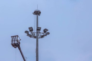 Sokak lambasıyla metal direğin montajı sırasında kaldırma kovasında elektrik akımı.