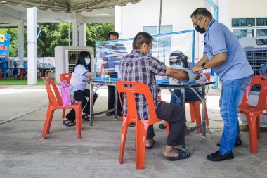 KANCHANABURI, THAILAND-AĞUSTOS 25. 2021: Kimliği belirsiz kişiler Tayland 'ın aşı süreci boyunca tüm yetişkinlere ilk doz COVILO (Sinopharm) Coronavirus aşısı için kuyrukta bekliyorlar.