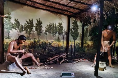 UDON THANI, THAILAND-NOVEMBER 20. 2020: Sergide, Ban Chiang Ulusal Müzesi 'ndeki Paleolitik insanların faaliyetlerini ve yaşam tarzlarını gösteren diyoramalar veya yontulmuş modeller yer alıyor..