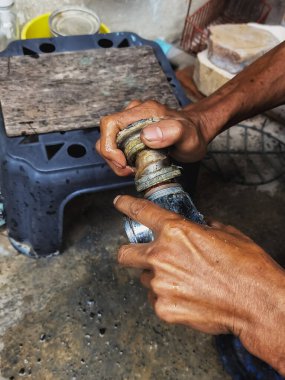 Ellerindeki tıkanmış lavabo borusu, mutfaktaki tıkanmış musluk borusunu temizleyen bir tesisatçı. Tıkanmış paslı su tuzağı hortumu ve drenaj borusu temizliği. Ev tesisat bakım servisi. DIY kavramı