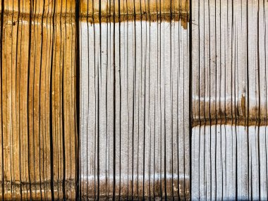 Vertical dry bamboo fence texture for pattern and background. Decorative old bamboo fence or wall texture background for design. Split bamboo pieces bundled together to form a simple fence or wall.