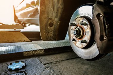 Kontrol et ve değiştir, fren diski veya pervane ve fren kalibresini onar. Arabaya fren diski ve fren kalibresi takıldı. Fren mekanizmalı araba süspansiyonu. Seçici odak, arkaplan bulanık.