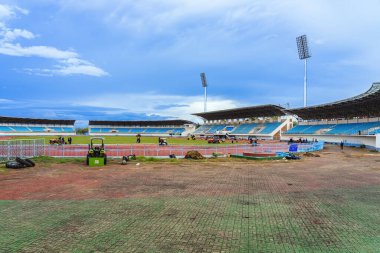 KANCHANABURI, THAILAND-AĞUSTOS 8, 2025: Kleeb Bua Stadyumu 'ndaki profesyonel spor sahası projesi için hazırlanmış topraklara taze çimen tohumu döşeyen tanımlanamayan peyzaj işçileri ekibi.