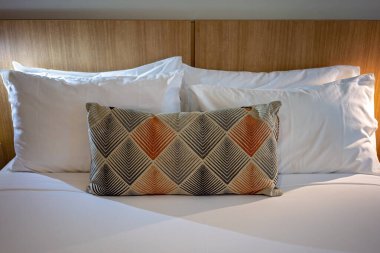 Yastıklı ve dekoratif yastıklı bir otel odasında.