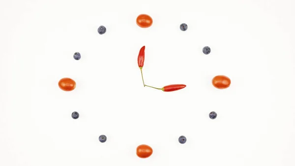 Eine Uhr Aus Kirschtomaten Blaubeeren Und Roten Chilischoten Auf Weißem — Stockfoto