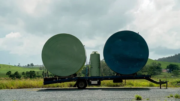 Três Tanques Água Chuva Carregados Reboque Deixados Desengatados Lado Uma — Fotografia de Stock