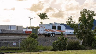 Mackay, Queensland, Avustralya - Ocak 2021: Otoyol üst geçidi inşa eden bir inşaat şirketi için mobil ofis olarak kiralanmış bir minibüs