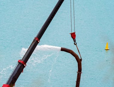 Deniz suyu pompalayan endüstriyel bir hortumu kapatın.