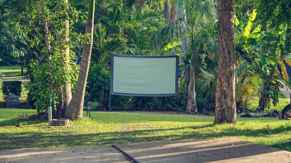 An outdoor movie screen in a tropical tourist caravan park for guest viewing