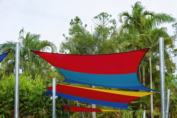Colourful sails covering a children\'s playground to provide shade and keep the sun away