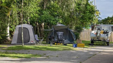 Airlie Beach, Queensland, Avustralya - Şubat 2021: Kampçılar, tekneleri ve balıkçılık ekipmanlarıyla bir turizm parkında tatil yapıyorlar