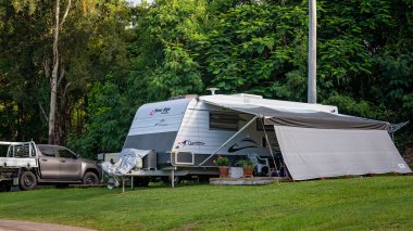 Airlie Beach, Queensland, Avustralya - Şubat 2021: Tropikal bir turizm parkında karavan yaşam tarzının tadını çıkaran tatilciler