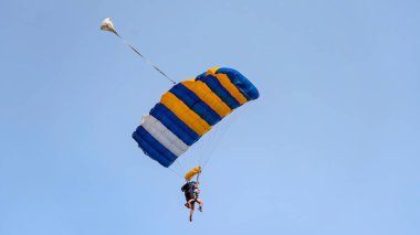 Açık mavi gökyüzüne karşı paraşütle atlamaya hazır ikili hava dalgıçları.