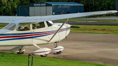 Airlie Beach, Queensland, Avustralya - Şubat 2021: Havaalanı pistinin yanına park edilmiş hafif bir uçak