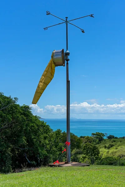 A yellow windsock to measure wind speed and direction against a clear sky