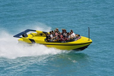 Airlie Beach, Queensland, Avustralya - Nisan 2021: Yolcular WhitSunday 'lerde okyanusta bir jet botta adrenalin gezintisi yaparken eğleniyorlar