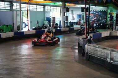 Mackay, Queensland, Australia - April 2021: A young girl drives a go-kart in a fun recreational drive around a circuit in public