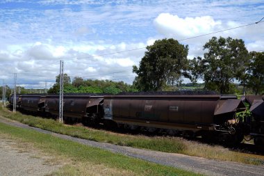 Mackay, Queensland, Avustralya - Mayıs 2021: Gemi yükleme için limana giden elektrik raylarında ihracat kömürü yüklü tren