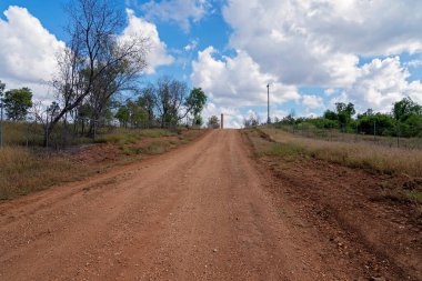 Copperfield Queensland Avustralya 'da eski bakır rafinerisine giden toprak yolda tuğla baca duruyor.