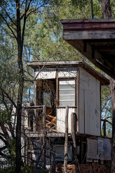 一座古老的废弃的小木屋 在灌木丛中的高低杠上 — 图库照片