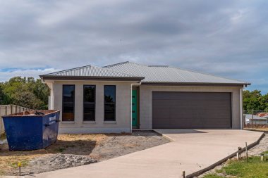 Mackay, Queensland, Avustralya - Mayıs 2021: Bir taşra kasabasındaki bir banliyö sokağında ilk sakinlerini bekleyen yeni inşa edilmiş bir ev, konut patlaması