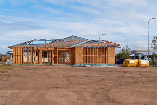 Mackay, Queensland, Australia - May 2021: A house frame being constructed on a suburban street in a country town, city housing boom