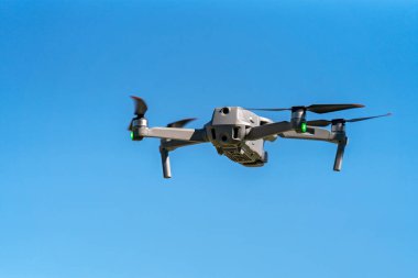 Açık mavi gökyüzüne karşı uçan son teknoloji drone.