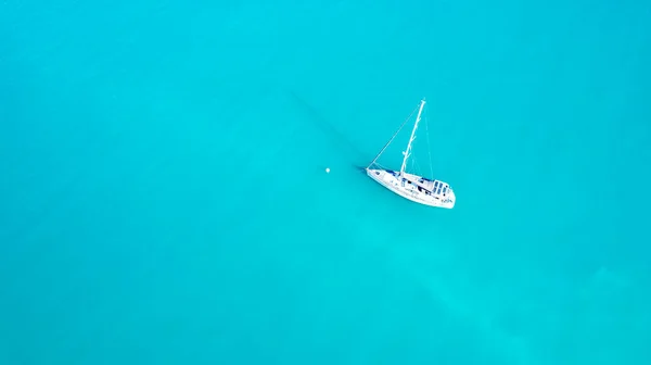 コーラル海のターコイズブルーの海に一人で停泊している白いヨットの上の空中ビュー — ストック写真