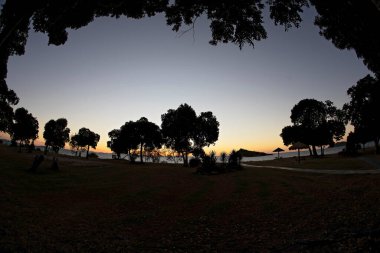 The light is fading as sunset approaches over the tropical resort on the beachfront with island view, fish eye lens