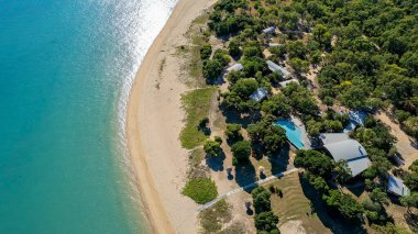 Cape Gloucester, Queensland, Australia - June 2021: Aerial view over a bushland beachfront resort with a sandy beach frontage