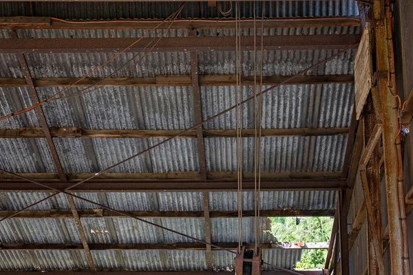 Eski paslanmış bir ülkenin iç çatısı. İhmalkarlıktan dökülen demir levhalarla birlikte.
