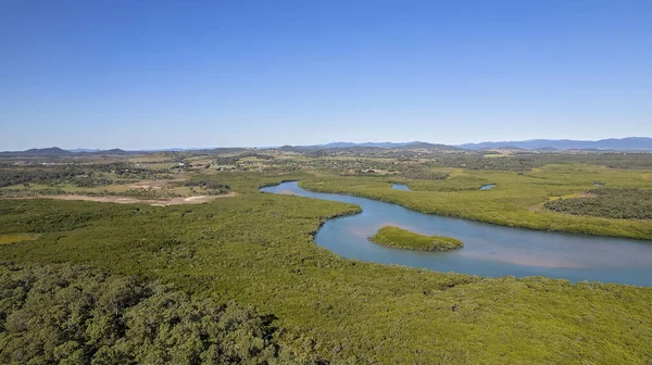 Aerial of conservation park which runs alongside a creek. Sandringham Bay Conservation Park, Mackay, Queensland, Australia.