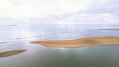Yumuşak odaklı, rüya gibi pastel renginde kumlu bir kumsalın görüntüsü.