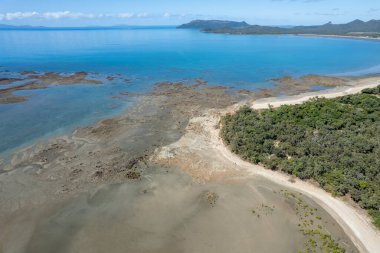 Kum ve çamur düzlüklerini gösteren alçak gelgitte kıyı şeridi havası. Seaforth, Queensland, Avustralya