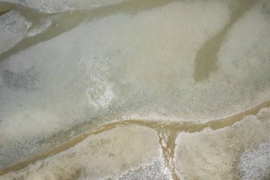 Dalgalar alçaldığında okyanus manzarası soyut şekillerde kumsalları ve deniz suyunu gösteriyor. Cape Hillsborough, Queensland, Avustralya