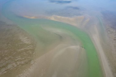 Dalgalar alçaldığında okyanus manzarası soyut şekillerde kumsalları ve deniz suyunu gösteriyor. Cape Hillsborough, Queensland, Avustralya