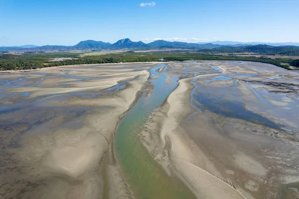 Aerial landscape of ocean at low tide looking towards land showing sandbanks and seawater. Cape Hillsborough, Queensland, Australia